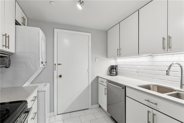 kitchen featuring dishwasher, white cabinets, stacked washing maching and dryer, and sink