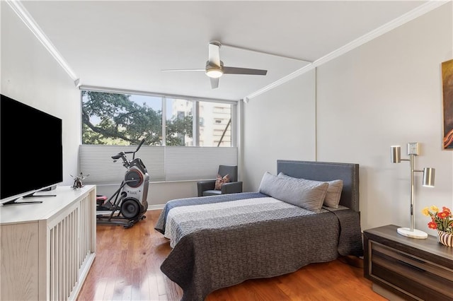 bedroom featuring ceiling fan, ornamental molding, and hardwood / wood-style flooring