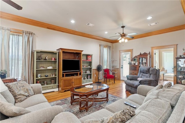 living room featuring light hardwood / wood-style flooring, ceiling fan, and ornamental molding