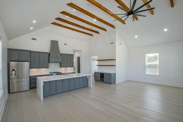 kitchen featuring custom range hood, stainless steel appliances, sink, an island with sink, and high vaulted ceiling