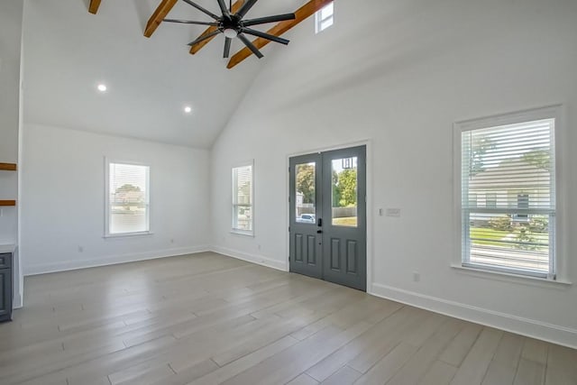 foyer entrance featuring ceiling fan, high vaulted ceiling, light hardwood / wood-style floors, and a wealth of natural light