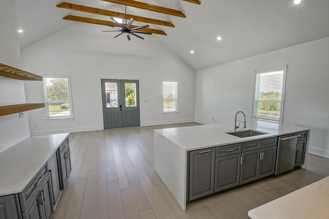 kitchen with sink, dishwasher, an island with sink, and gray cabinets