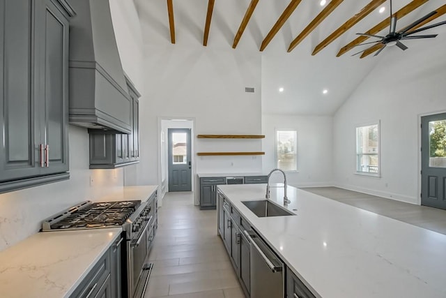 kitchen with sink, high vaulted ceiling, beamed ceiling, appliances with stainless steel finishes, and gray cabinets