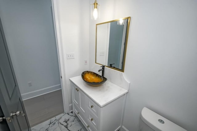 bathroom with toilet, vanity, and tile patterned floors