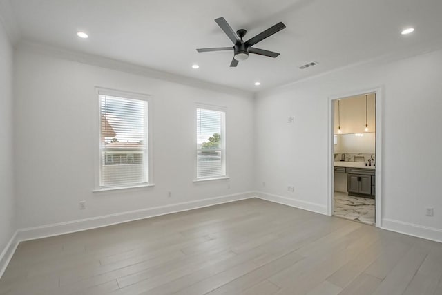 unfurnished bedroom with light tile patterned floors, crown molding, ceiling fan, and ensuite bathroom