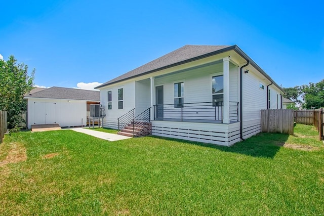 back of house with a patio and a lawn