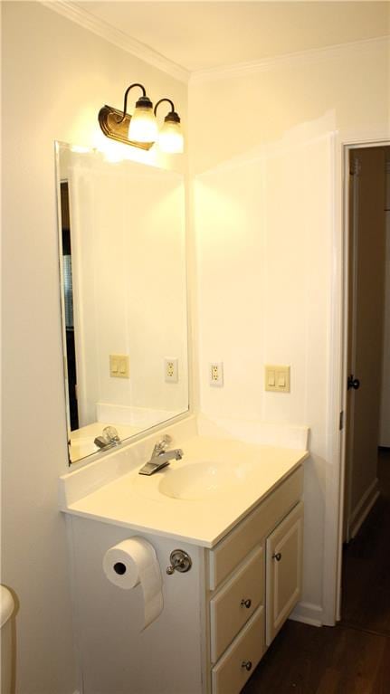 bathroom with vanity, toilet, ornamental molding, and wood-type flooring