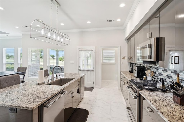 kitchen featuring a healthy amount of sunlight, a center island with sink, stainless steel appliances, and sink