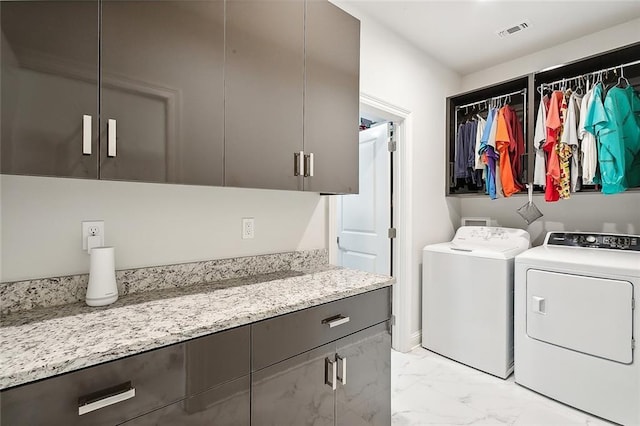 laundry room featuring cabinets and washing machine and dryer