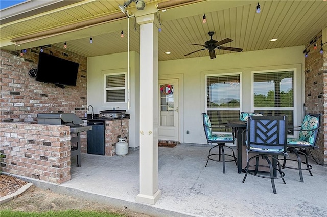 view of patio featuring ceiling fan, area for grilling, and sink