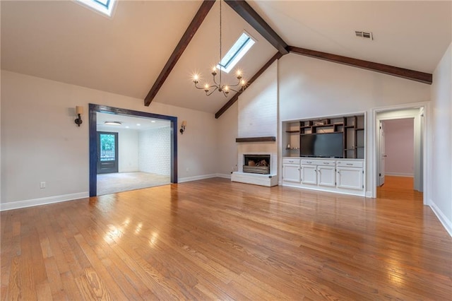 unfurnished living room with high vaulted ceiling, a skylight, a chandelier, and light hardwood / wood-style floors