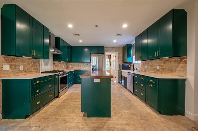 kitchen featuring green cabinets, stainless steel appliances, and a center island