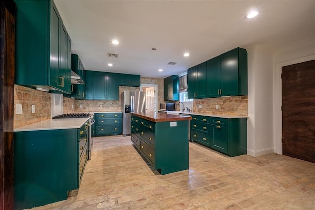 kitchen with green cabinetry, stainless steel appliances, tasteful backsplash, and a kitchen island