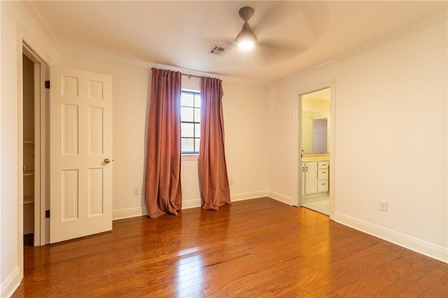 empty room with ornamental molding, hardwood / wood-style floors, and ceiling fan