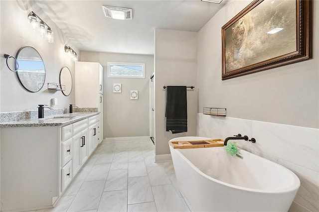 full bath featuring visible vents, marble finish floor, a freestanding tub, and vanity