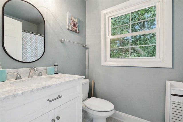 bathroom featuring toilet, vanity, and a healthy amount of sunlight