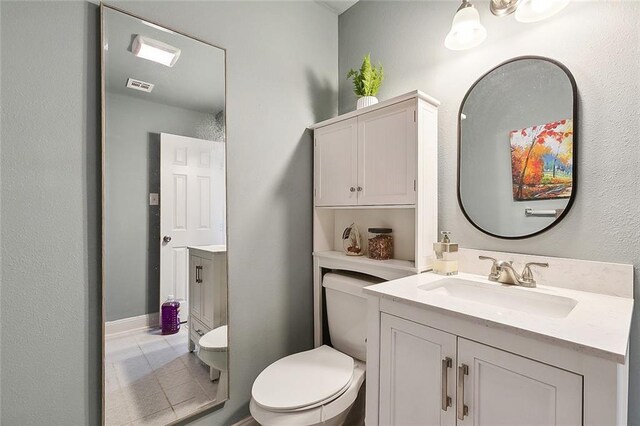 bathroom with tile patterned floors, vanity, and toilet