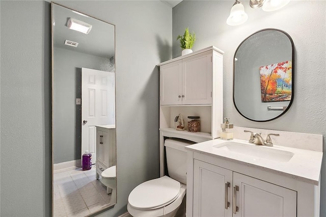 half bathroom with toilet, tile patterned flooring, vanity, and visible vents