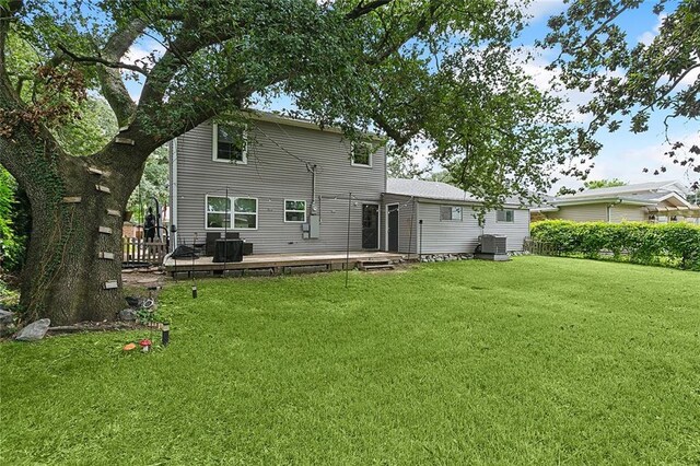 back of property with a yard and a deck