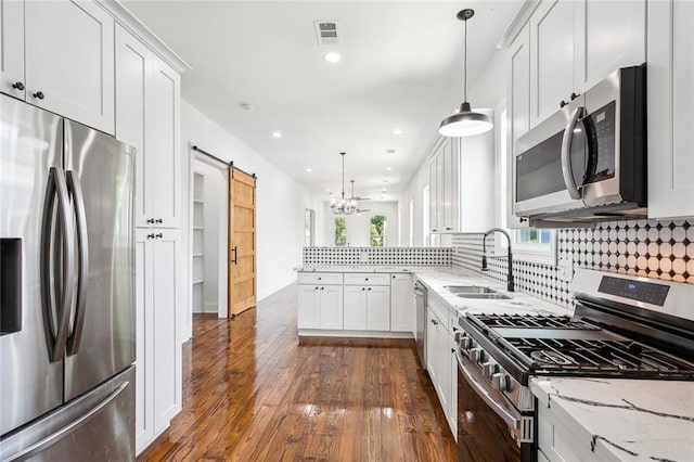 kitchen featuring stainless steel appliances, decorative backsplash, dark hardwood / wood-style flooring, and light stone counters