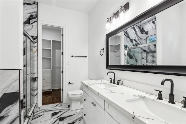 bathroom featuring wood-type flooring, a shower with shower door, vanity, and toilet