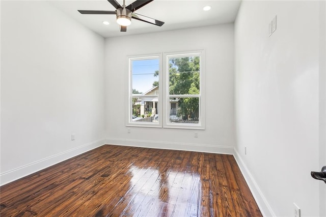 empty room with ceiling fan and dark hardwood / wood-style flooring