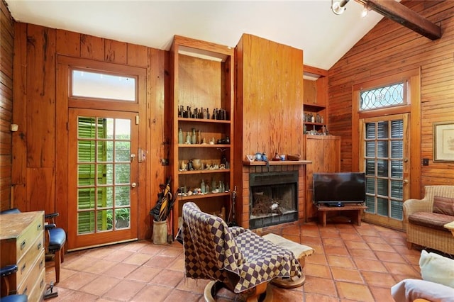 tiled living room featuring wooden walls, beam ceiling, and high vaulted ceiling