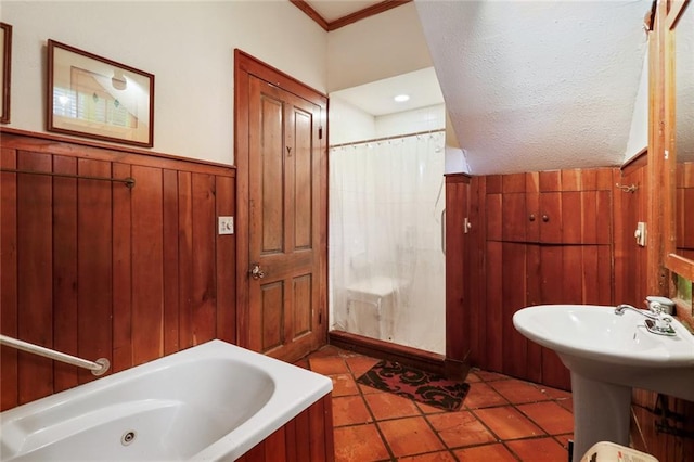 bathroom featuring a textured ceiling, wooden walls, shower / tub combo, and crown molding