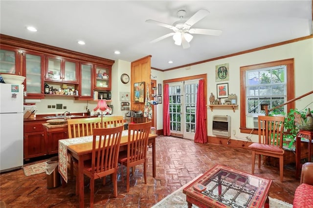 dining area with ceiling fan, heating unit, and crown molding