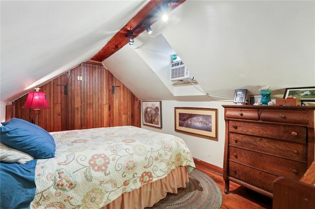 bedroom with wooden walls, vaulted ceiling, and hardwood / wood-style flooring