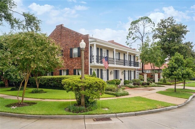 view of front of property with a balcony and a front yard