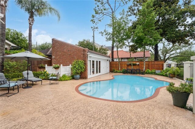 view of swimming pool featuring french doors and a patio