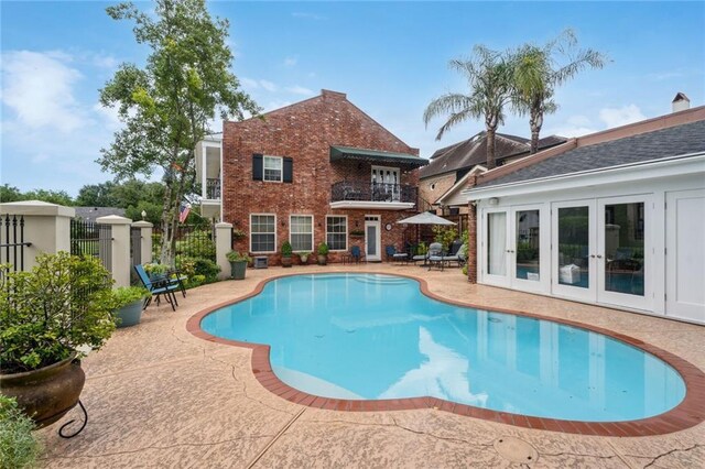 view of swimming pool featuring a patio and french doors