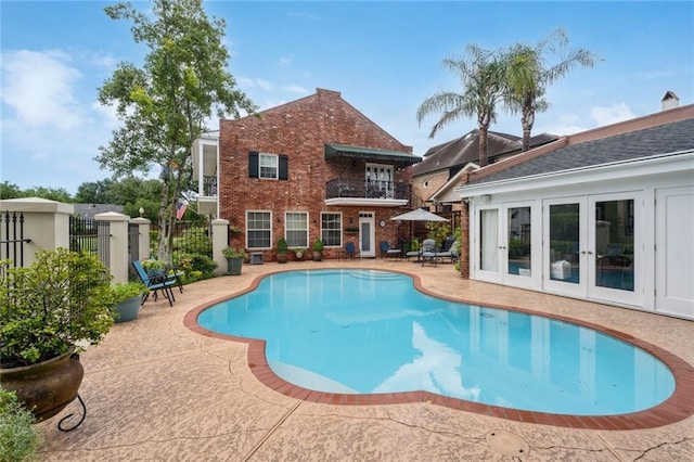 view of swimming pool with a patio area, fence, a fenced in pool, and french doors