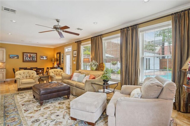 tiled living room with ceiling fan and ornamental molding