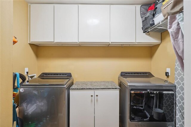 washroom featuring separate washer and dryer and cabinets