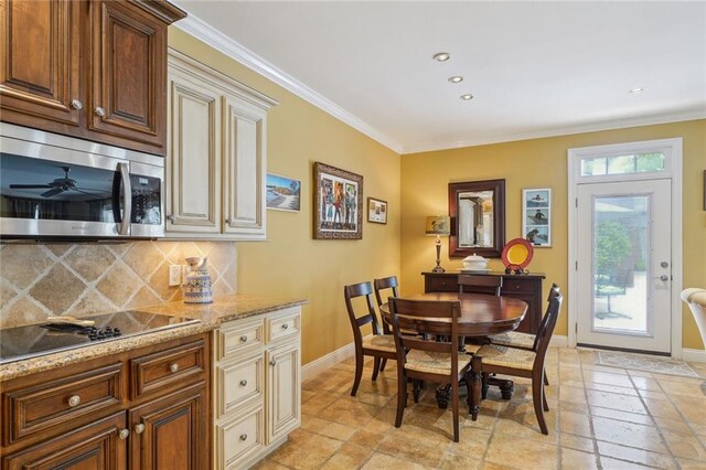 dining area featuring ceiling fan, crown molding, and light tile patterned floors