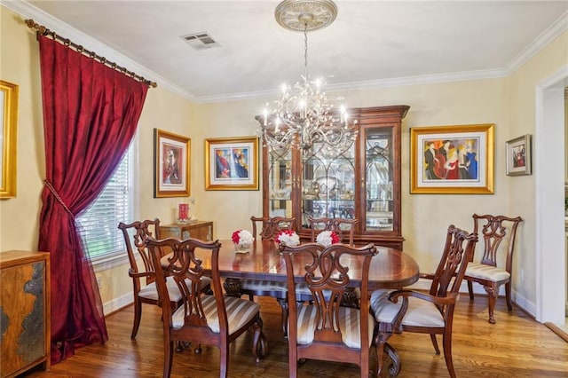 dining area with baseboards, visible vents, wood finished floors, and ornamental molding