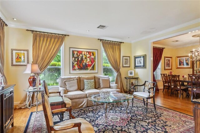 living room with a healthy amount of sunlight, light wood-type flooring, and a chandelier