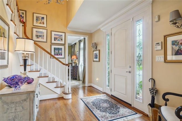 entryway with crown molding and light wood-type flooring