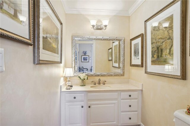 bathroom featuring toilet, crown molding, and vanity