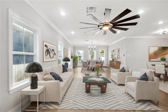 living area featuring light wood-type flooring, recessed lighting, visible vents, and crown molding