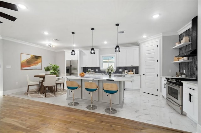 kitchen featuring white cabinets, appliances with stainless steel finishes, open shelves, and light countertops