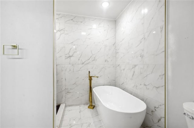 bathroom with a freestanding bath, marble finish floor, walk in shower, and toilet