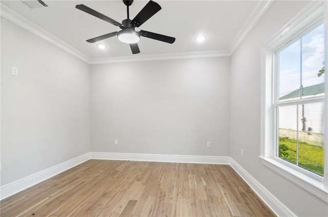 empty room with crown molding, light wood-type flooring, plenty of natural light, and baseboards