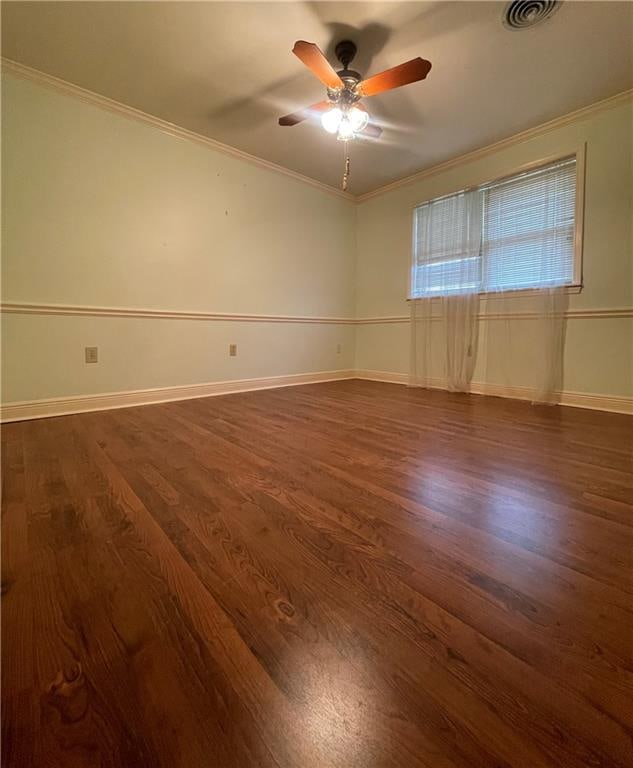 unfurnished room featuring ceiling fan, dark wood-type flooring, and crown molding