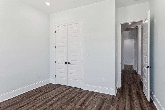 unfurnished bedroom with a closet and dark hardwood / wood-style flooring