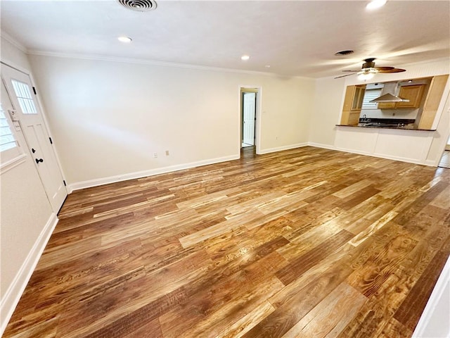 unfurnished living room featuring ceiling fan, hardwood / wood-style floors, and ornamental molding