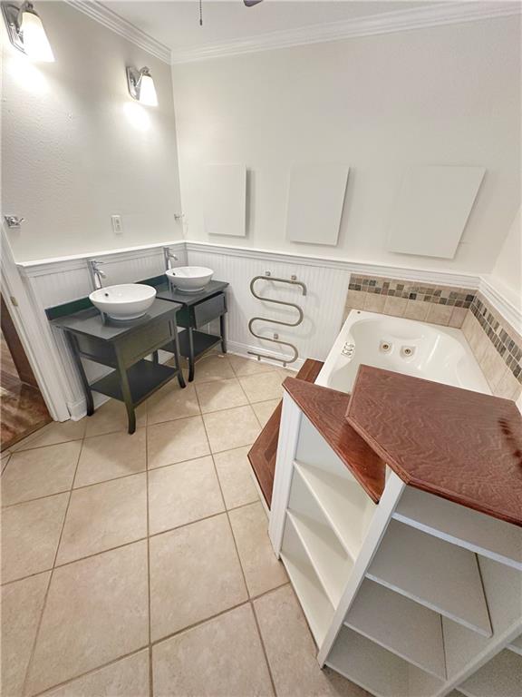 interior space featuring sink, tile patterned flooring, a bathtub, and crown molding