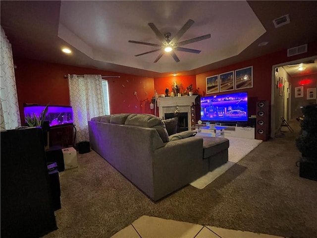 living room featuring ceiling fan, a raised ceiling, and carpet floors